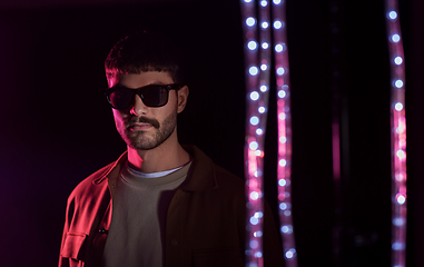 Image showing man in sunglasses over neon lights at nightclub