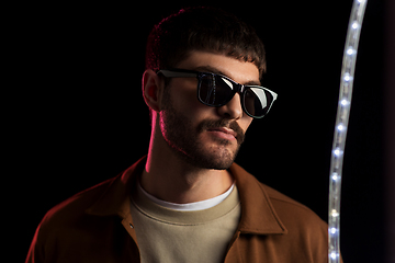 Image showing man in sunglasses over neon lights at nightclub