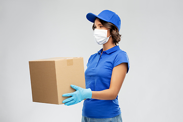 Image showing delivery woman in face mask holding parcel box