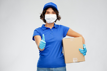 Image showing delivery woman in face mask holding parcel box