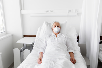 Image showing old woman patient in mask lying in bed at hospital