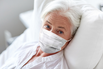 Image showing old woman patient in mask lying in bed at hospital