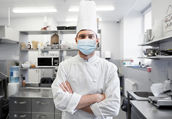 Image showing male chef with in face mask at restaurant kitchen