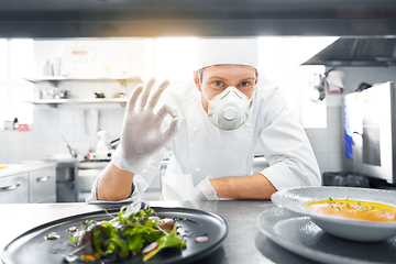 Image showing male chef in mask with food at restaurant kitchen