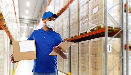 Image showing delivery man in mask with parcel box and clipboard