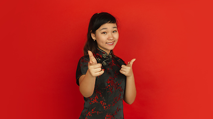 Image showing Happy Chinese new year. Asian young girls\'s portrait isolated on red background