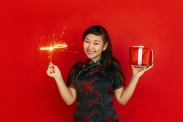 Image showing Happy Chinese New Year. Asian young girls\'s portrait isolated on red background