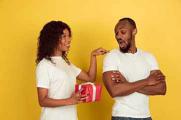 Image showing Valentine\'s day celebration, happy african-american couple isolated on yellow background