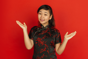 Image showing Happy Chinese new year. Asian young girls\'s portrait isolated on red background