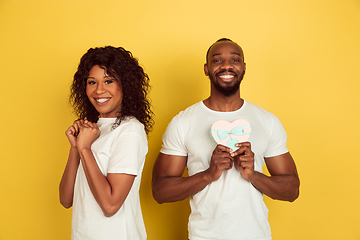 Image showing Valentine\'s day celebration, happy african-american couple isolated on yellow background