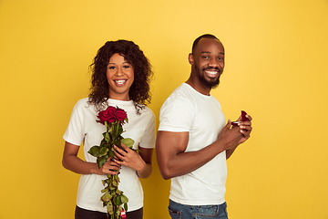 Image showing Valentine\'s day celebration, happy african-american couple isolated on yellow background