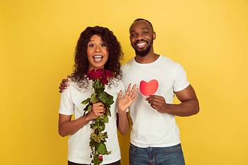 Image showing Valentine\'s day celebration, happy african-american couple isolated on yellow background