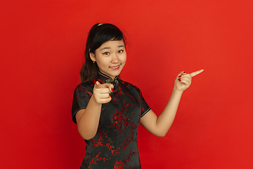 Image showing Happy Chinese new year. Asian young girls\'s portrait isolated on red background