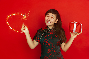 Image showing Happy Chinese New Year. Asian young girls\'s portrait isolated on red background