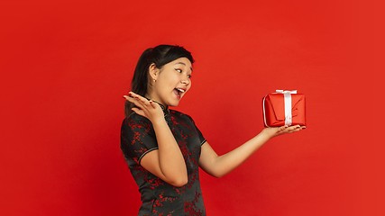 Image showing Happy Chinese New Year. Asian young girls\'s portrait isolated on red background