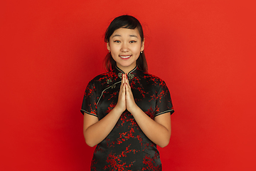 Image showing Happy Chinese new year. Asian young girls\'s portrait isolated on red background