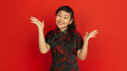 Image showing Happy Chinese new year. Asian young girls\'s portrait isolated on red background