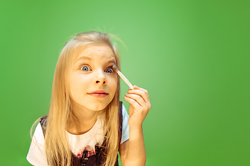 Image showing Little girl dreaming about future profession of makeup artist