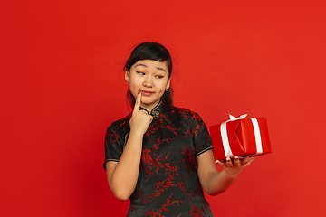 Image showing Happy Chinese New Year. Asian young girls\'s portrait isolated on red background