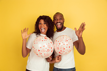 Image showing Valentine\'s day celebration, happy african-american couple isolated on yellow background