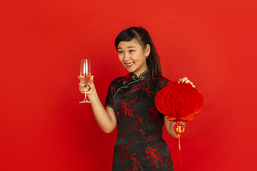 Image showing Happy Chinese New Year. Asian young girls\'s portrait isolated on red background