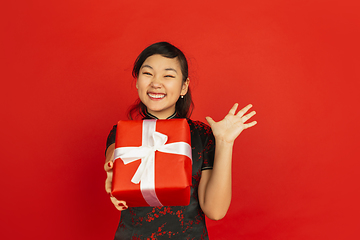 Image showing Happy Chinese New Year. Asian young girls\'s portrait isolated on red background