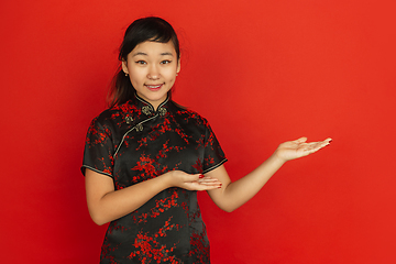 Image showing Happy Chinese new year. Asian young girls\'s portrait isolated on red background