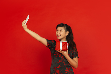 Image showing Happy Chinese New Year. Asian young girls\'s portrait isolated on red background