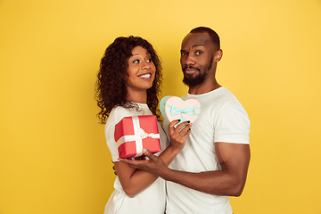 Image showing Valentine\'s day celebration, happy african-american couple isolated on yellow background