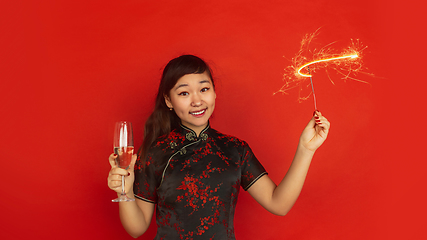 Image showing Happy Chinese New Year. Asian young girls\'s portrait isolated on red background