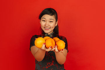 Image showing Happy Chinese New Year. Asian young girls\'s portrait isolated on red background