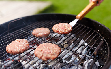 Image showing close up of meat cutlets roasting on grill