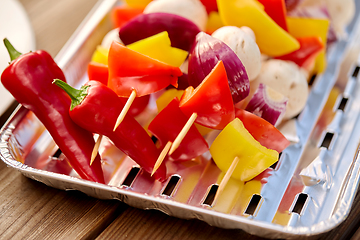 Image showing close up of vegetables on skewers on foil grill