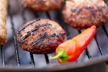 Image showing burger meat cutlets and pepper roasting on grill