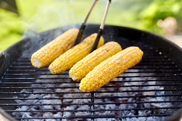 Image showing close up of corn roasting on grill outdoors