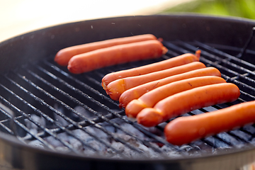 Image showing meat sausages roasting on hot brazier grill