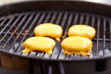 Image showing close up of meat cutlet with cheese on grill