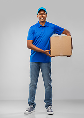 Image showing happy indian delivery man with parcel box in blue