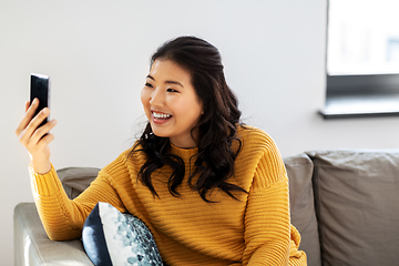 Image showing asian woman taking selfie with smartphone at home