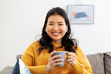 Image showing woman in earphones listening to music at home