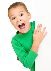 Image showing Little girl is looking out from the blank banner