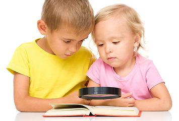 Image showing Little girl and boy are reading book