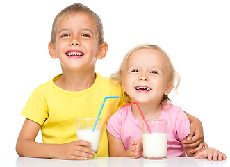 Image showing Cute little girl and boy are drinking milk