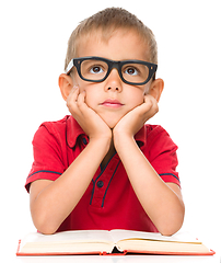 Image showing Little boy is reading a book