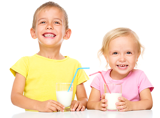 Image showing Cute little girl and boy are drinking milk