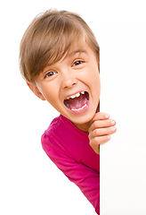 Image showing Little girl is looking out from the blank banner