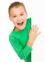 Image showing Little girl is looking from out blank board