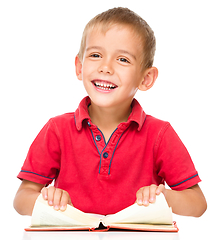 Image showing Little boy is reading a book