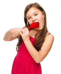 Image showing Portrait of a little girl biting red heart