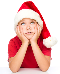 Image showing Little girl in santa hat is daydreaming